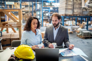Business people checking list and inventory on laptop at warehouse